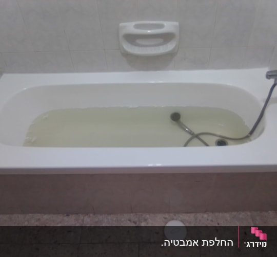 אמבטיה עם מים עכורים וברז מחובר לקיר